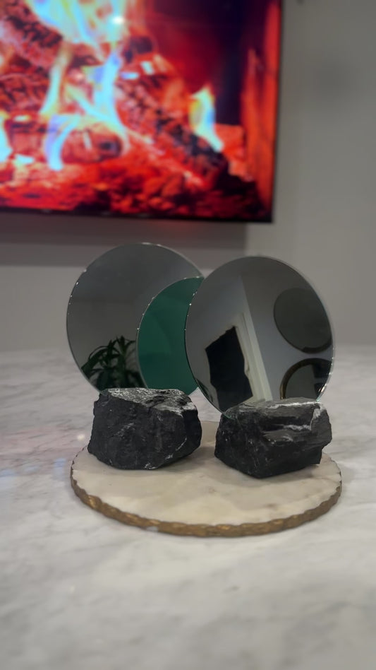 Two round mirrors on a black marble base